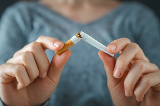 A woman breaking a cigarette in two